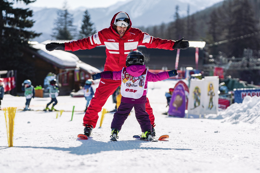 Enfant en cours de ski avec un moniteur